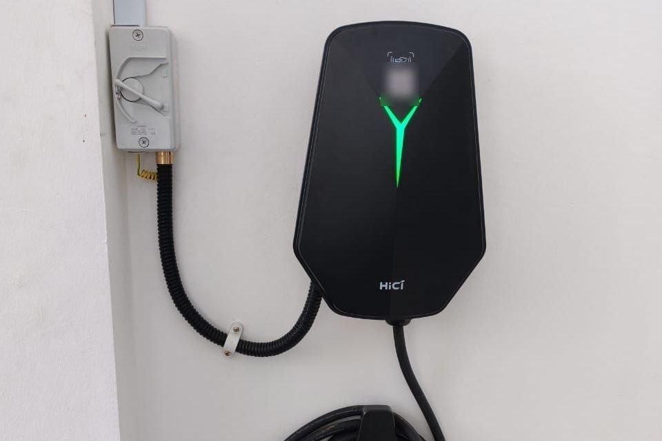 HiCi wall charger installed on a white wall, its supply run in conduit from the isolator switch beside it